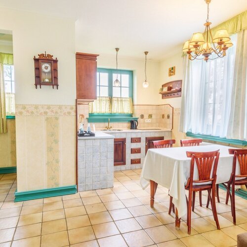 Aneks kuchenny w apartamencie willowym ze stołem i krzesłami dla czterech osób