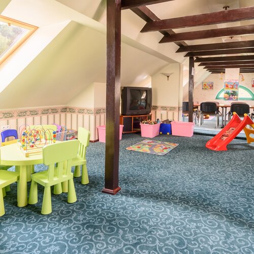 Sala zabaw dla dzieci ze stolikiem i krzesełkami do zabawy oraz różnymi zabawkami