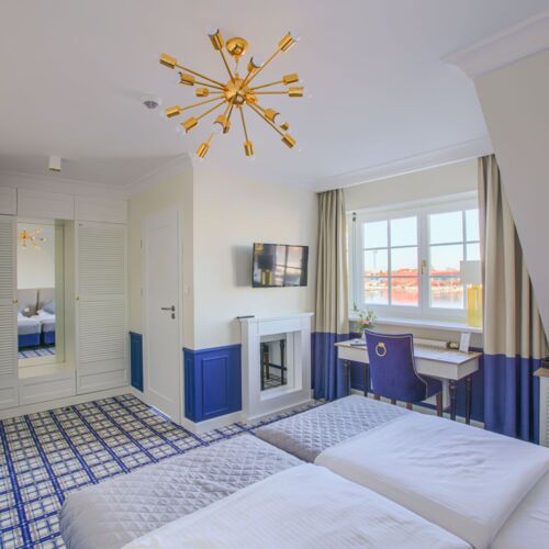 Nowoczesny pokój hotelowy z dwoma łóżkami, biurkiem i dużym oknem