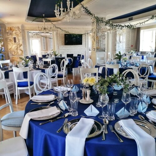 Uroczyście nakryte okrągłe stoły w Restauracji w Zatoce z okazji przyjęcia weselnego