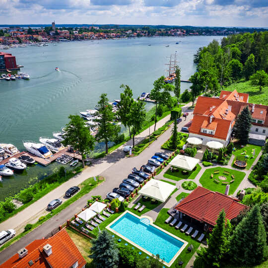 Widok z lotu ptaka na marinę z jachtami i budynki hotelowe z ogrodem i basenem zewnętrznym