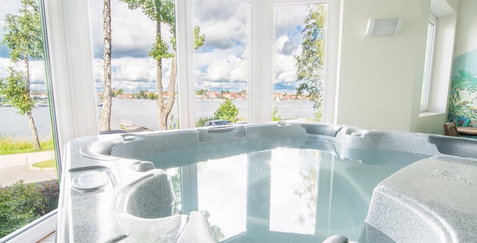Jacuzzi z widokiem na jezioro przez duże okna