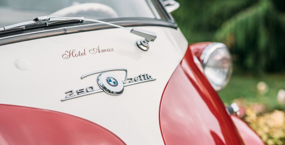Zbliżenie na przód zabytkowego samochodu BMW z logo hotelu Amax