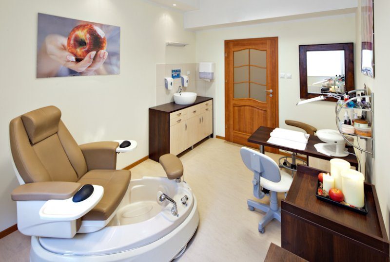 Spa-Pedicure-Raum mit lederner Liege und Fußbad, Maniküretisch, Waschbecken, Handtüchern, Kerzen und Pflegeprodukten.