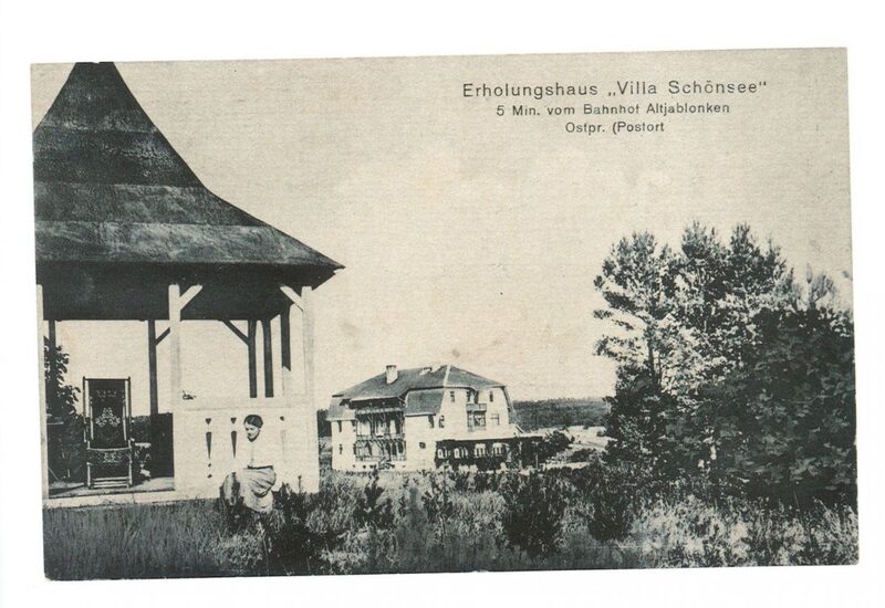 Historische Villa mit Veranda und Pavillon, Gast sitzt auf dem Rasen, umgeben von Bäumen und Wiese