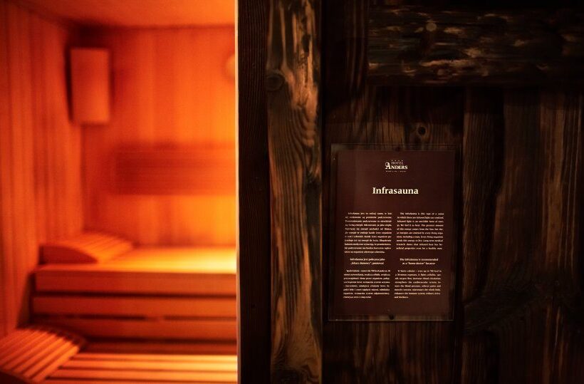 Warm beleuchtete Infrasauna mit Holzliegen und Innenlampe, Bereich des Hotel‑Spas zum Entspannen.
