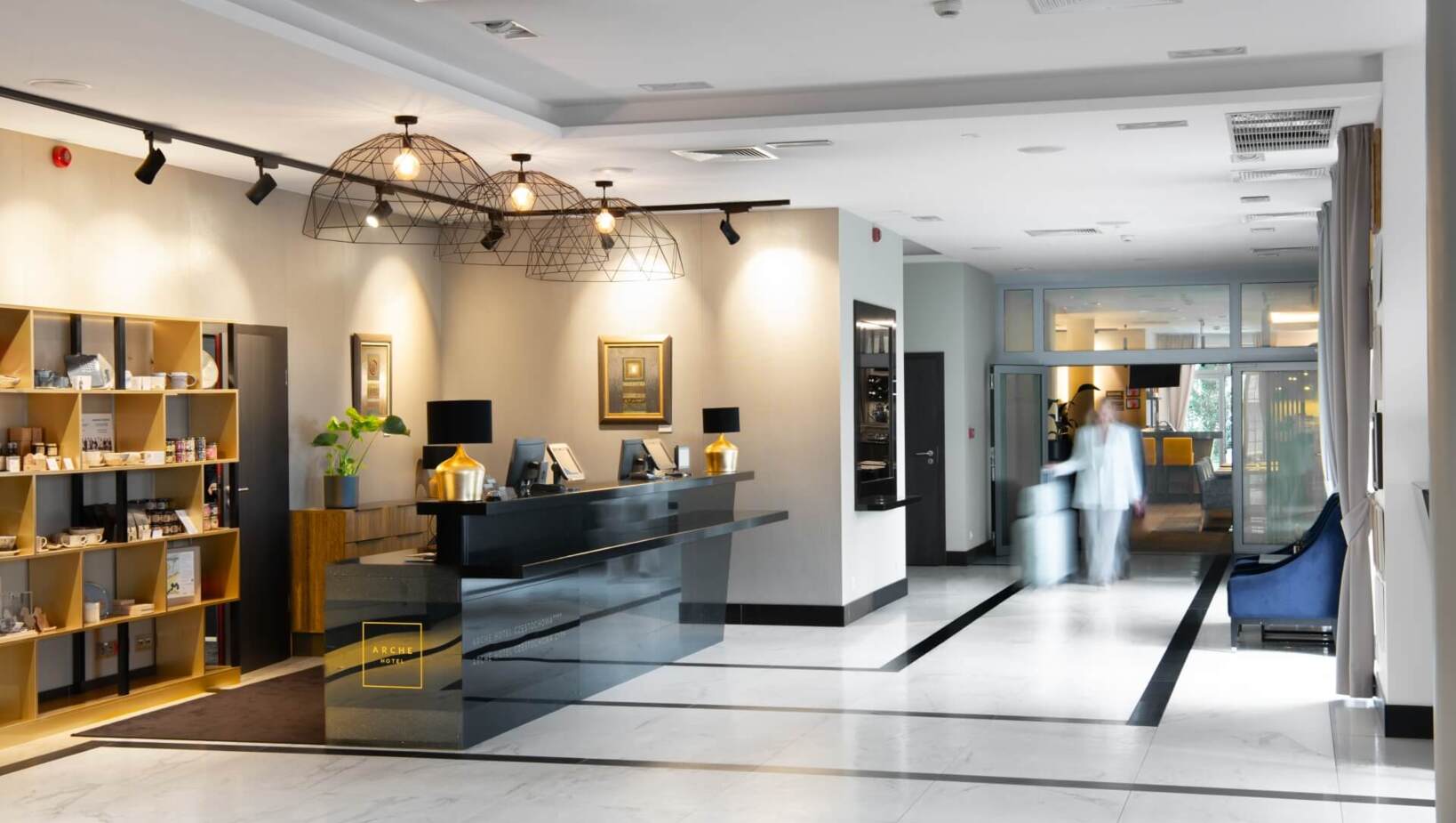 Korytarz recepcji hotelowej w eleganckim stylu z kobietą przechodzącą korytarzem z walizką