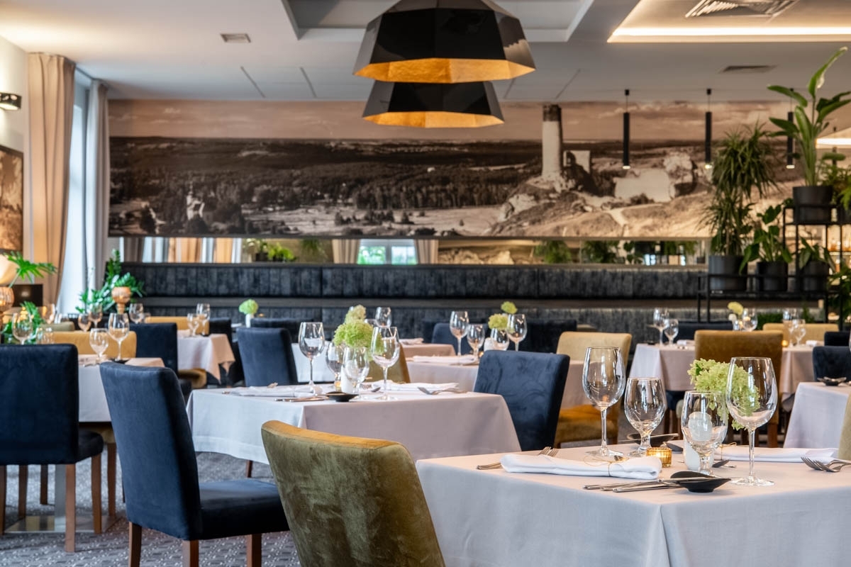 Sala restauracyjna z zastawą na stołach przygotowaną dla gości z wygodnymi krzesłami