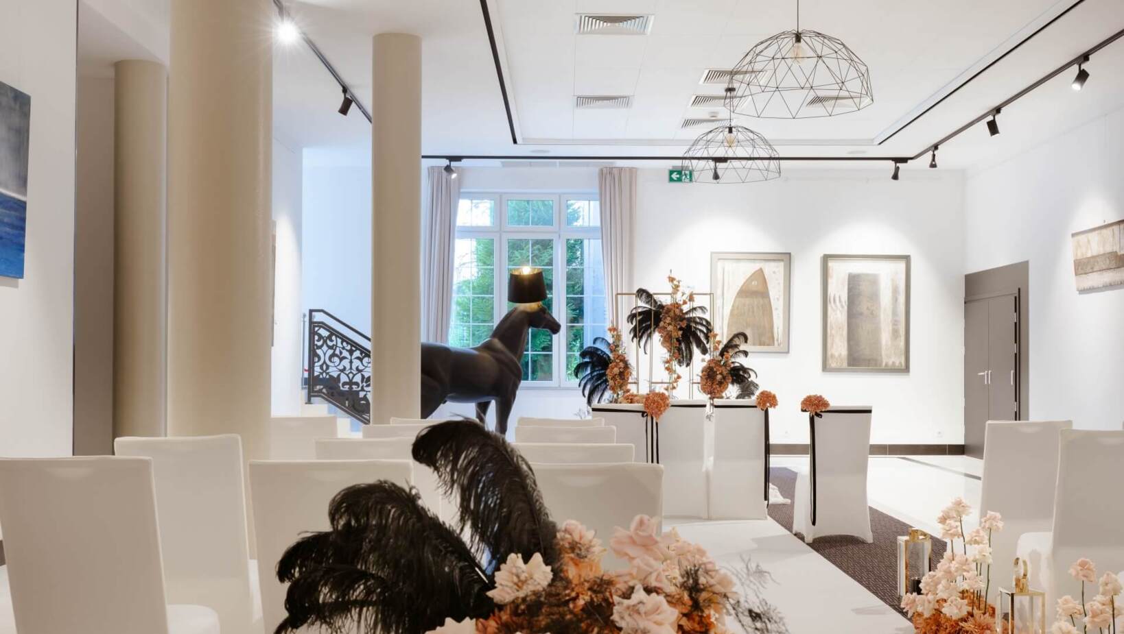 Elegancki jasny korytarz hotelowy, przyozdobiony świeżymi kwiatami z rzeźbą w tle