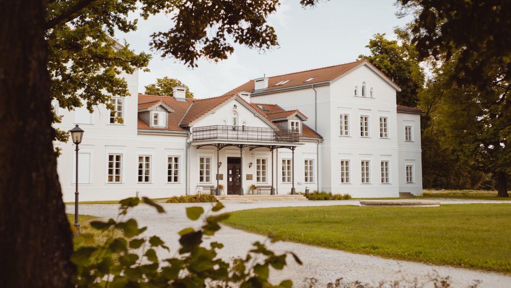 Widok budynku jednego z obiektów sieci hoteli Arche wśród roślinności