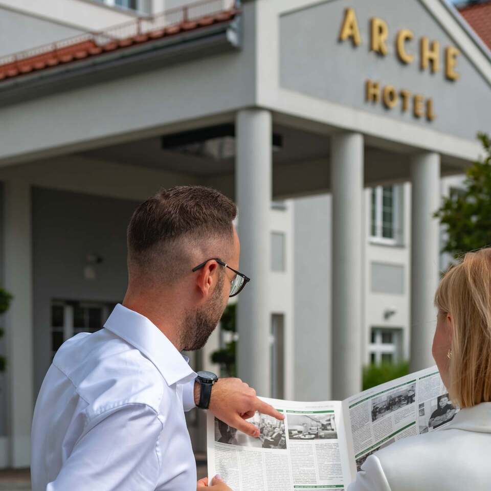 Pracownicy hotelu przed budynkiem Arche Częstochowa omawiający informacje dotyczące obiektu