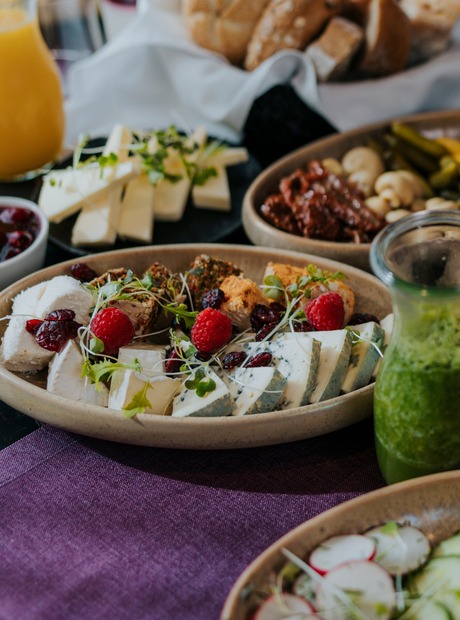 Frokostbuffé med croissanter, bakverk, oster, friske salater, brødkurv, grønn smoothie og appelsinjuice