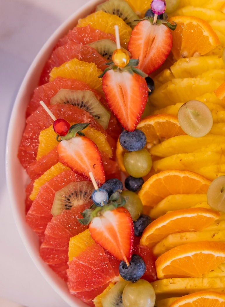 Bunter Hotel-Frühstücks-Obstteller mit Ananas-, Orangen-, Grapefruit- und Kiwischeiben sowie Erdbeeren und Beeren