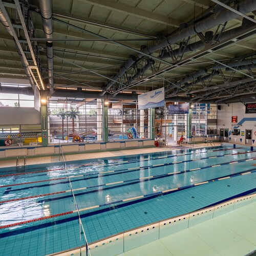 Indoor swimming pool with marked lanes, starting blocks, lifeguard and view of the leisure pool