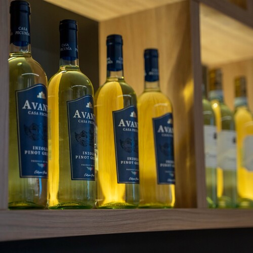 White wine bottles lit on a wooden hotel bar shelf, elegant labels and warm lighting