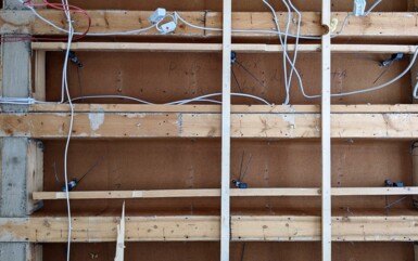Exposed wooden framework with electrical wiring during hotel room renovation or construction phase