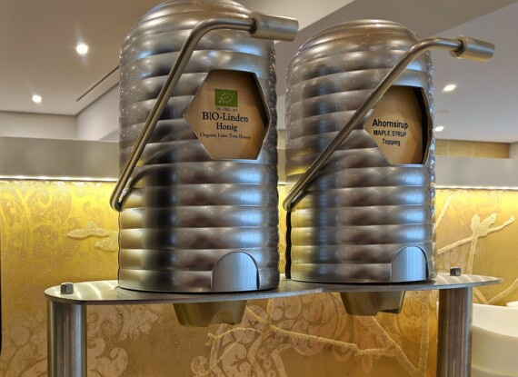 Edelstahlspender für Bio-Lindenhonig und Ahornsirup als Topping im Frühstücksbereich des Hotels
