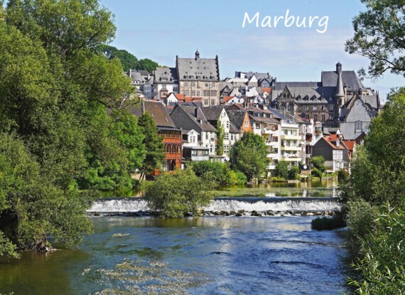 Historische Stadt Marburg mit steinernen Gebäuden, üppigem Grün und ruhigem Fluss mit kleinem Wehr