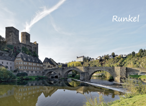 Historische Steinbrücke über einen ruhigen Fluss mit mittelalterlicher Burg und charmanten Häusern umgeben von grüner Landschaft in Runkel