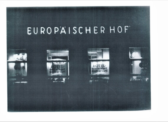 Nächtliche Ansicht der Fassade des Hotels Europäischer Hof mit beleuchtetem Schild und Fenstern von Restaurant und Café