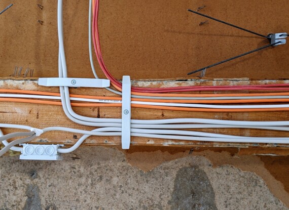 Close-up view of organized electrical wiring secured on a wooden board, highlighting neat cable management