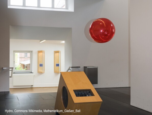 Moderner minimalistischer Hotellobby mit hellholzerner Rezeption, dunklen Fliesenboden und hellem Tageslicht durch hohe Fenster