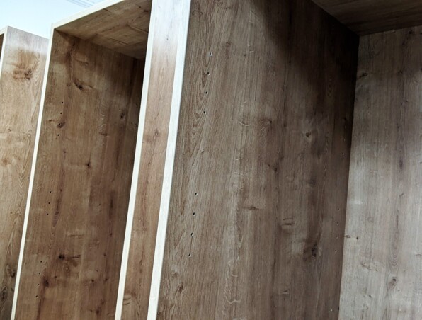 Close-up of empty wooden shelving units with natural wood grain, ready for customization in a hotel room closet or storage area