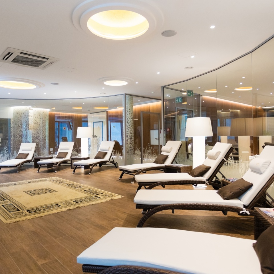 Luksusowa strefa relaksu z wygodnymi leżakami, miękkimi poduszkami i delikatnym oświetleniem w nowoczesnym spa hotelowym.