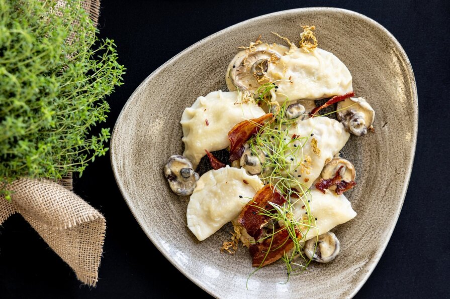 pierogi podane z grzybami i pieczonym boczkiem