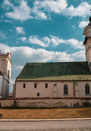 Historic white building with clock tower under blue sky with scattered clouds