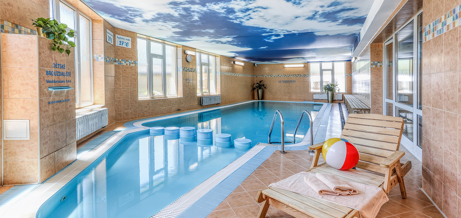 Vnitřní bazén Wellness & Aquacentra Slunce v Rýmařově v Jeseníkách s dětským brouzdalištěm, lehátky a příjemným zázemím pro rodinný odpočinek.