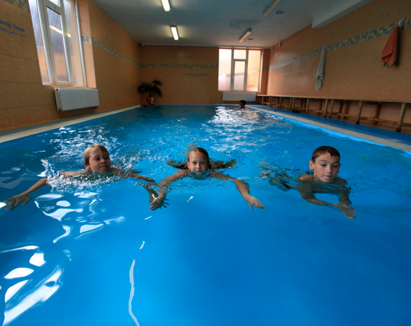 Děti si užívají prázdniny v bazénu Wellness & Aquacentra Hotelu Slunce Rýmařov v Jeseníkách během rodinné dovolené.