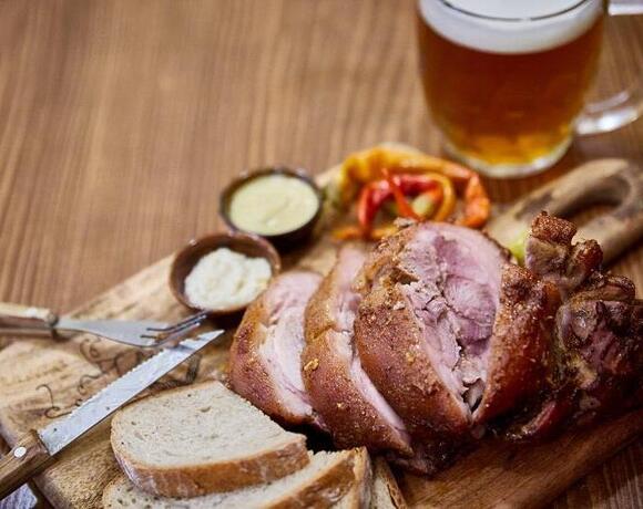 Plátky pečeného vepřového kolene podávané na dřevěném prkénku s čerstvým chlebem, hořčicí, křenem a nakládanou paprikou, doplněné půllitrem čepovaného piva z rodinného pivovaru Morous. Tradiční česká specialita servírovaná v restauraci Hotelu Slunce v Rýmařově v Jeseníkách.