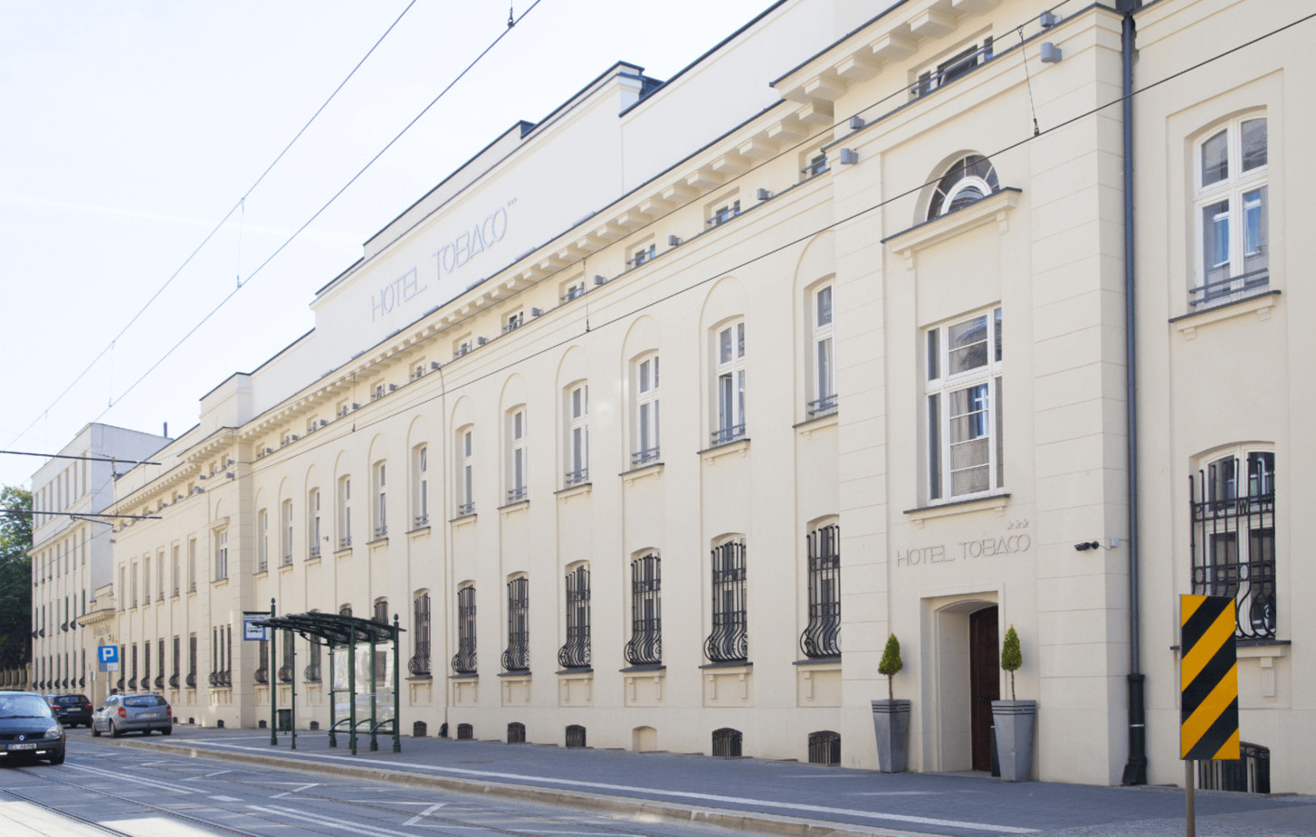 Bright facade of the hotel building next to the public transport stop