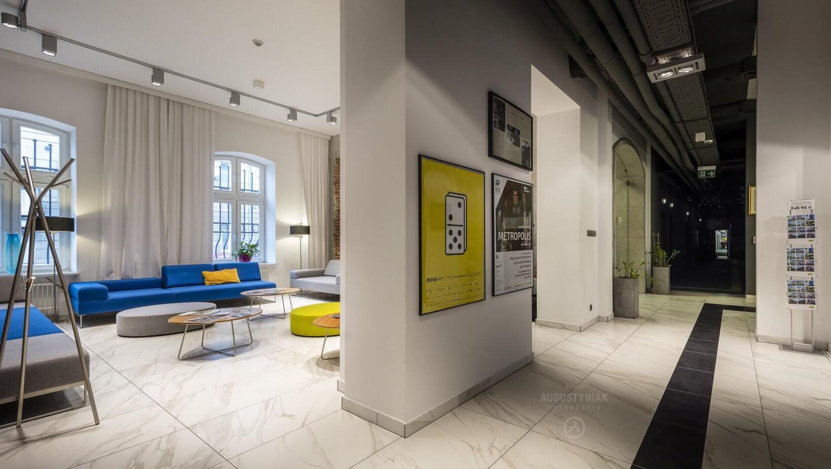 Hotel lobby with numerous paintings on the wall and comfortable sofas in the background