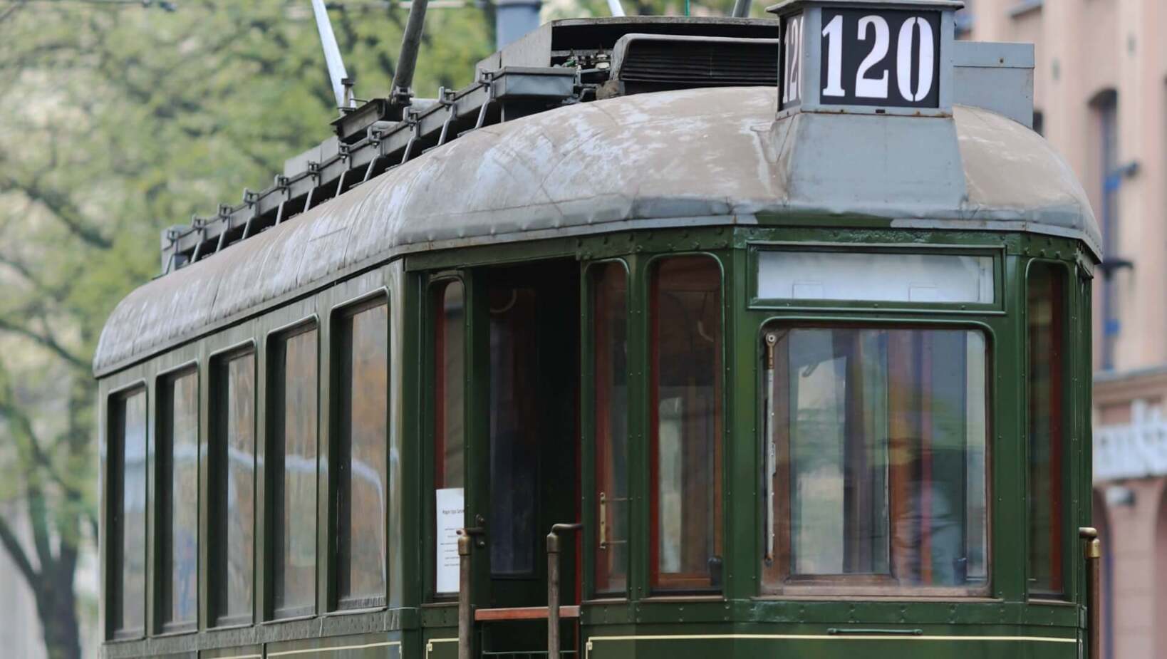 Historic tram in motion against the street and city buildings in Łódź