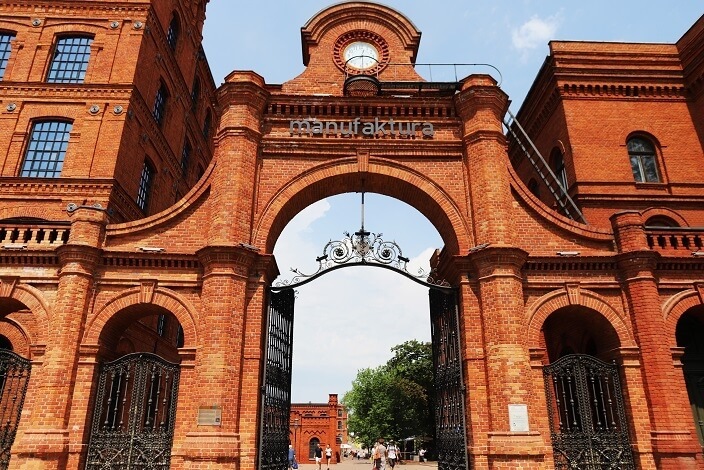 Entrance to the factory through a brick gate characteristic of industrial Łódź