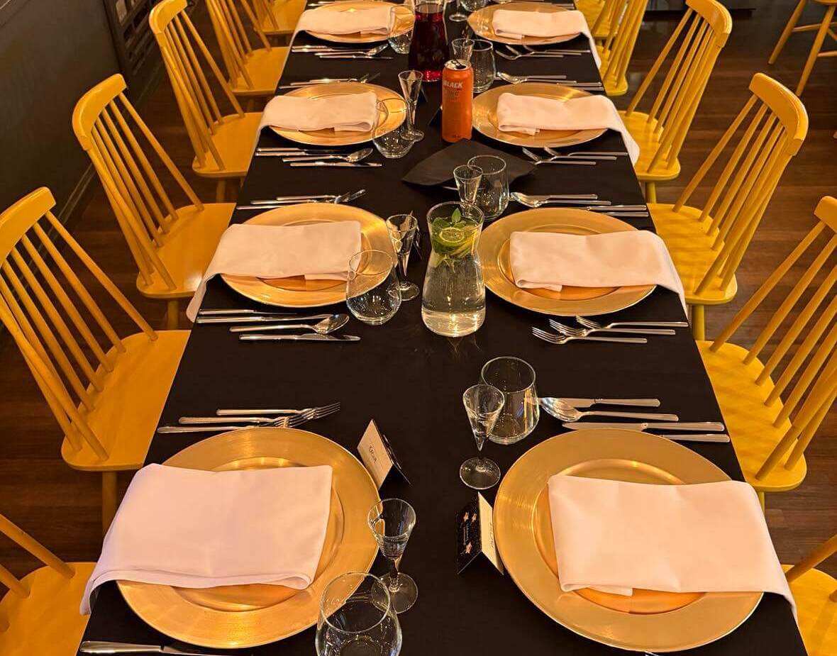 Ciepłe wnętrze sali restauracyjnej z dekoracją stołu w żółto-czarnej kolorystyce