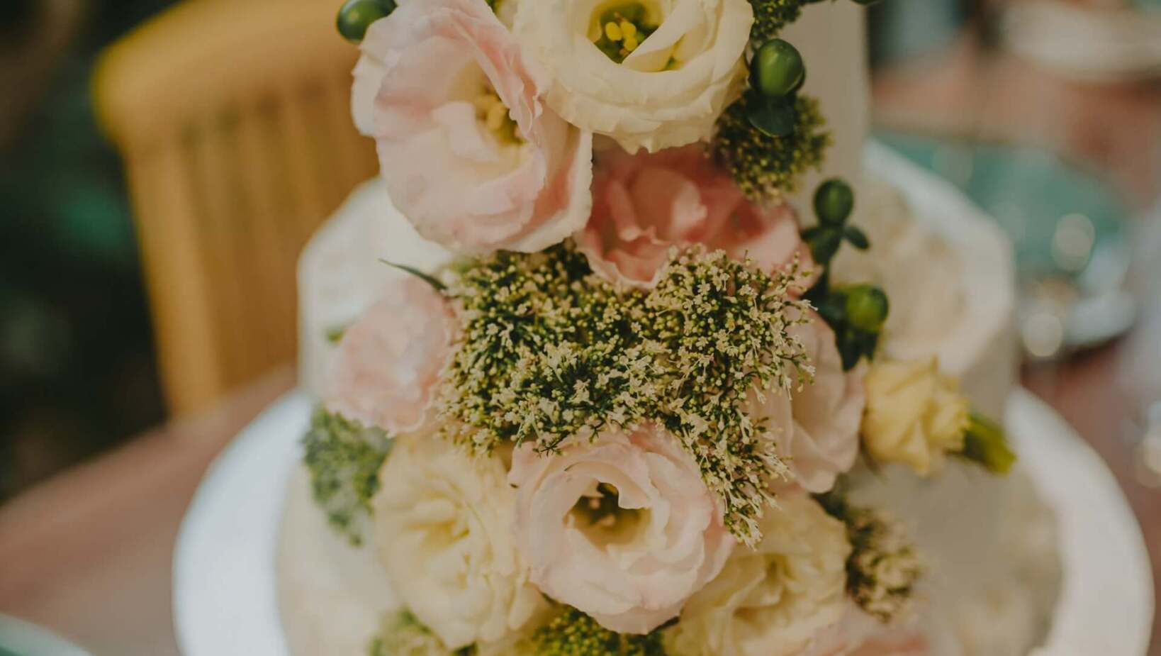 Piętrowy tort bogato ozdobiony kwiatami, idealny na uroczyste okazje