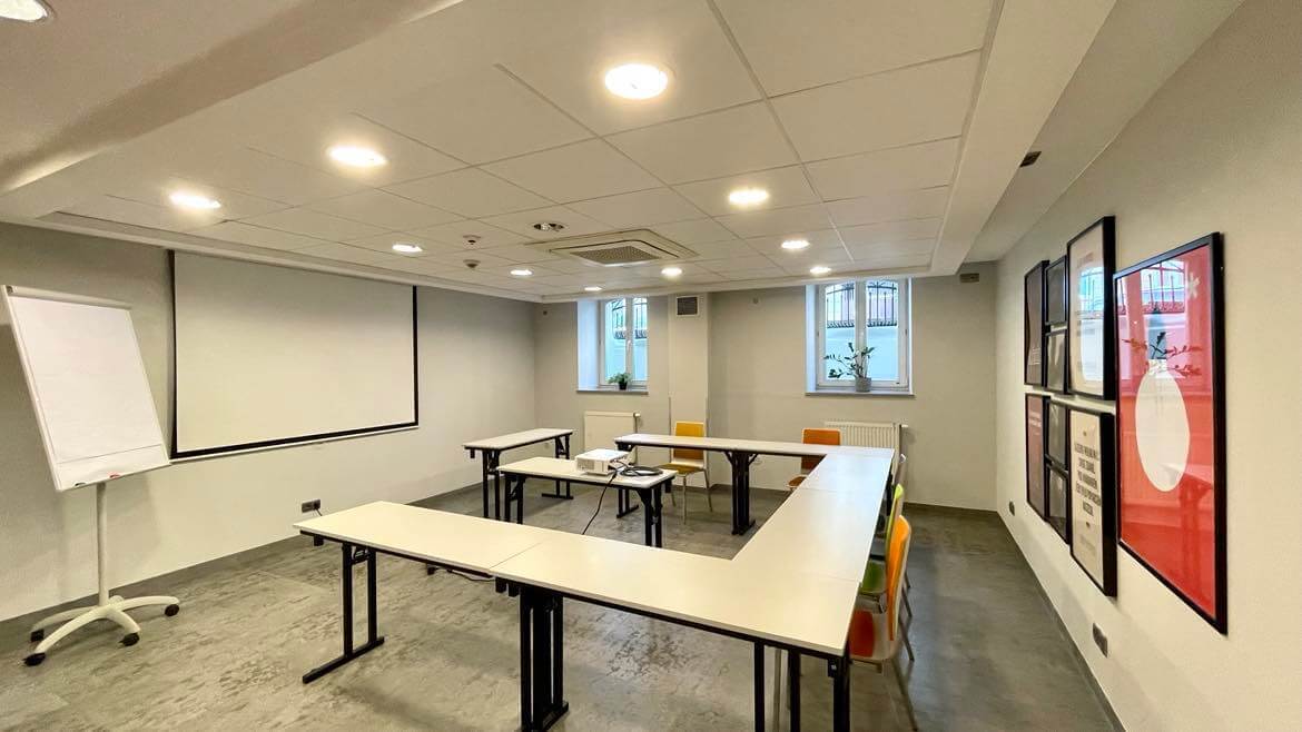 Mała sala konferencyjna z rzutnikiem i ekranem do prezentacji biznesowych