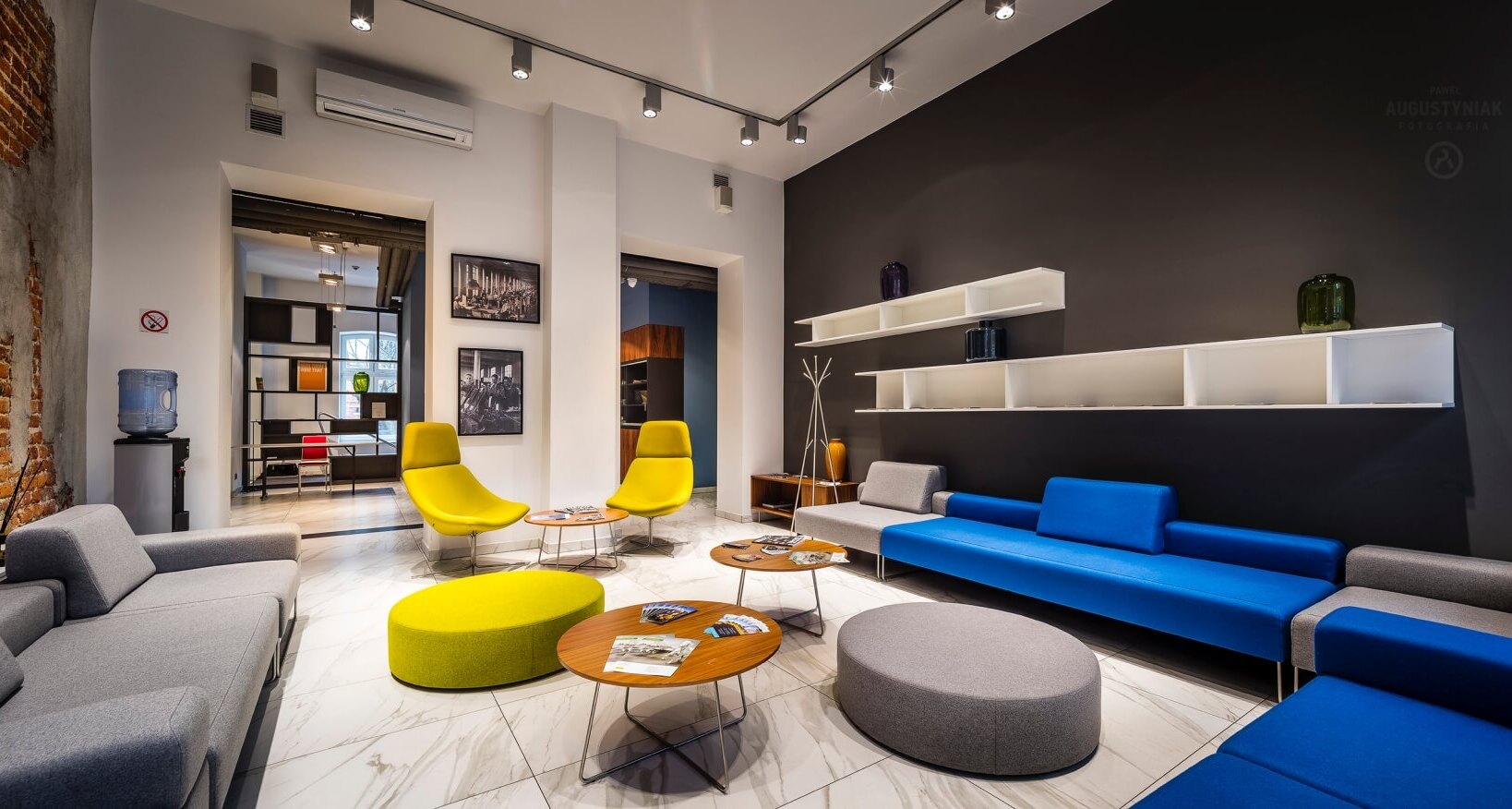 Hall przy recepcji hotelu z kolorowymi krzesłami, stolikami i wygodnymi kanapami