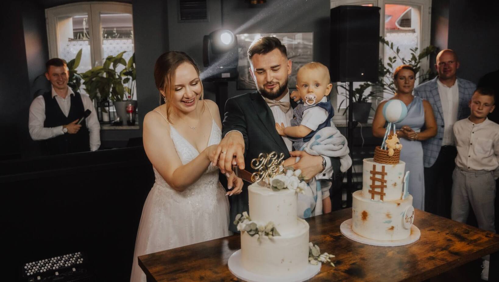 Parents holding a child while cutting cake during family celebration