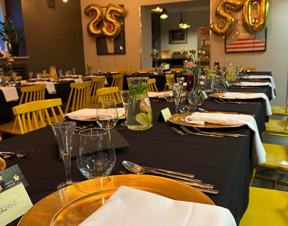 Tables in the dining room prepared for birthday with hanging balloons
