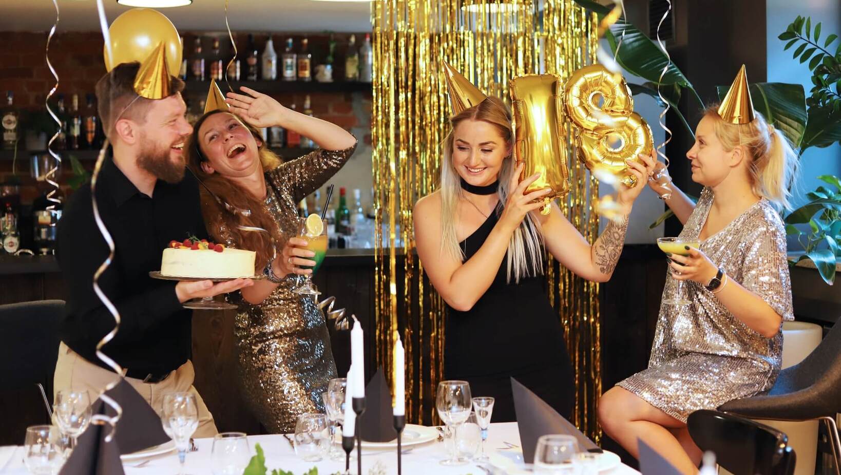 Friends celebrating 18th birthday at a set table with balloons and decorations