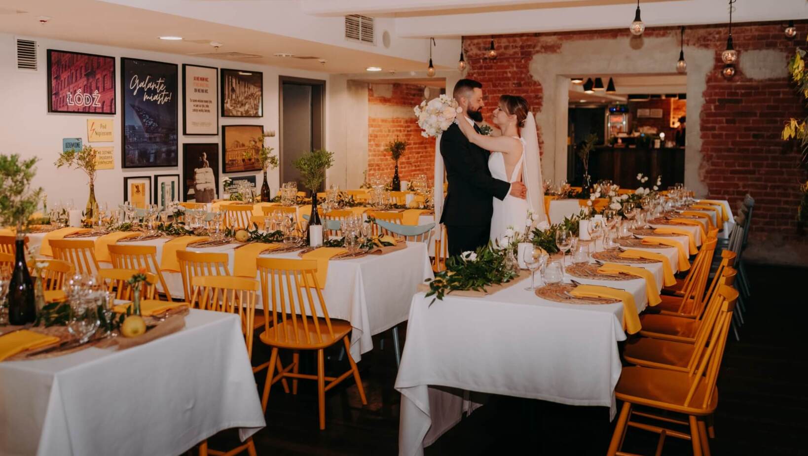 Para młoda wymieniająca czułości pomiędzy nakrytymi dla gości stolikami w sali restauracyjnej