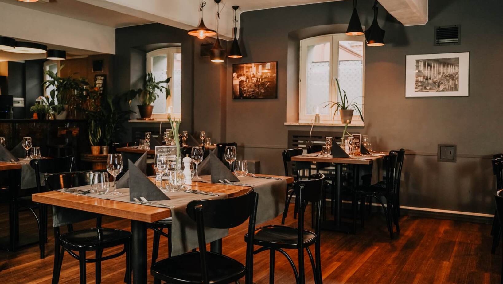 Sala restauracyjna przygotowana na gości z elegancko zastawionymi stołami