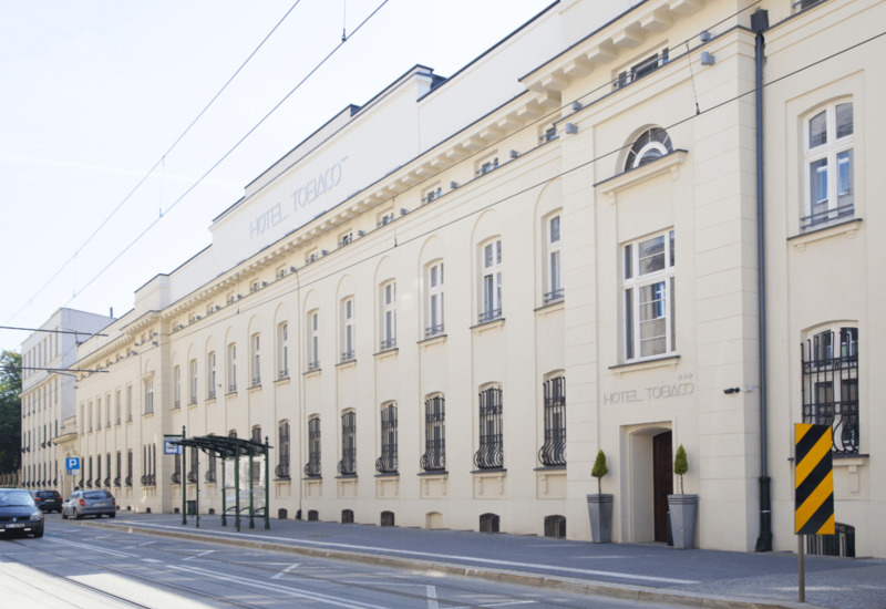 Bright facade of the hotel building next to the public transport stop