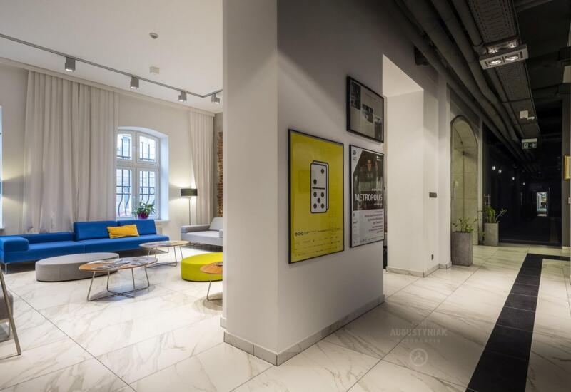 Hotel lobby with numerous paintings on the wall and comfortable sofas in the background