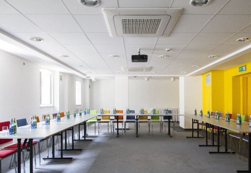 Conference room prepared for participants, with large daylight coming through the windows