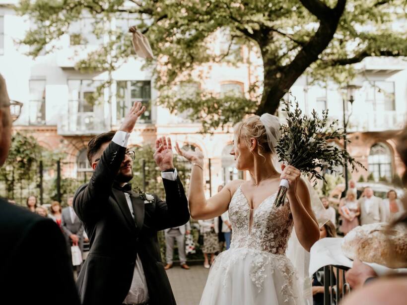 Bride and groom throwing glasses before entering the wedding hall in Tobaco Park Hotel Łódź